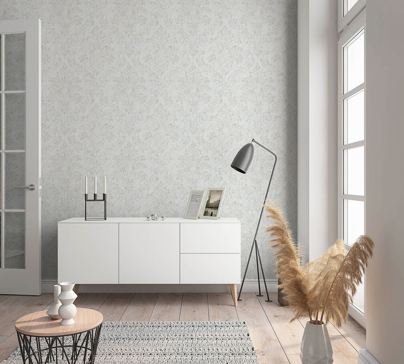 Soggiorno luminoso arredato con madia bianca moderna e parete decorata con carta da parati classica damascata grigio perla Europarati