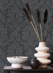 Particolare di ambientazione con la carta da parati damascata grigio antracite Europarati Friends 2434814, divano moderno e lampada di design