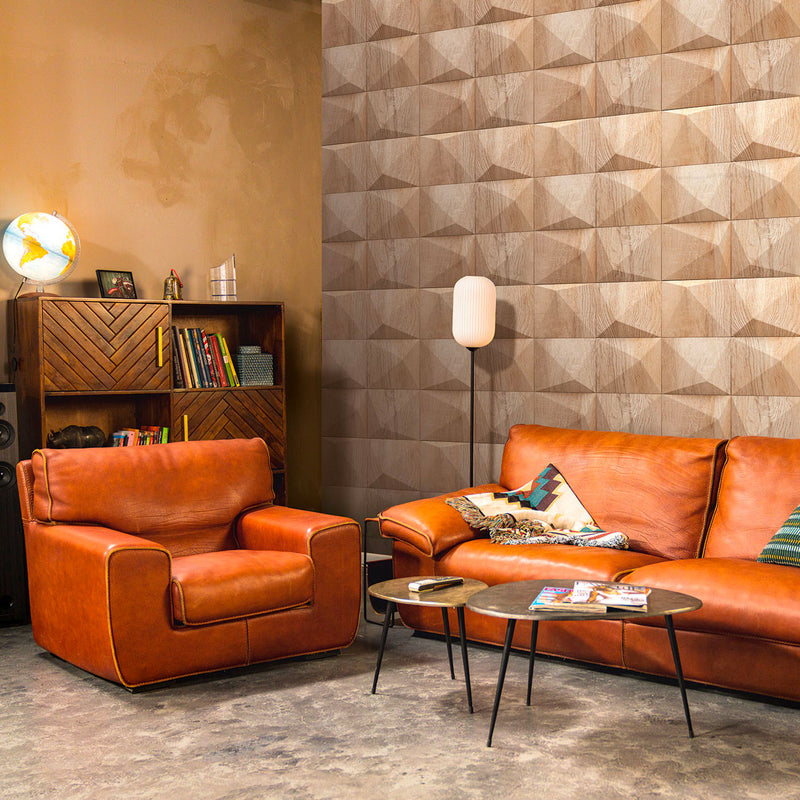 Parete di un soggiorno moderno rivestita con carta da parati Europarati Friends 2434851 effetto legno 3D a diamante, abbinata a divano e poltrona in cuoio color cognac