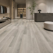 Pavimento SPC Baufloor Ghiaccio 6 mm effetto legno grigio chiaro in showroom e boutique