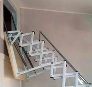 Dettaglio della scala retrattile Stalux installata in un vano a parete alto, con corrimano telescopico laterale per una salita sicura