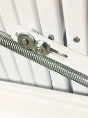 Primo piano del meccanismo di richiamo con molla in acciaio e bulloneria della scala retrattile, progettato per un'apertura fluida e bilanciata