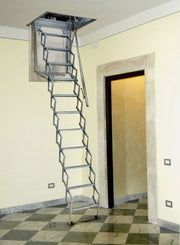 Vista d'insieme della scala a pantografo Starlux aperta in un corridoio con pavimento a scacchi. La foto mostra l'eleganza della struttura metallica e l'ingombro ridotto a terra