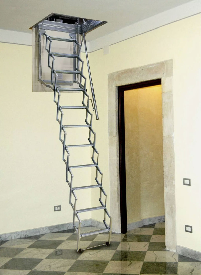 Vista d'insieme della scala a pantografo Starlux aperta in un corridoio con pavimento a scacchi. La foto mostra l'eleganza della struttura metallica e l'ingombro ridotto a terra