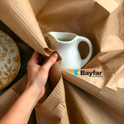 Mano che avvolge un oggetto fragile (brocca) con la carta da imballaggio Bayfar, ideale per una protezione sicura durante traslochi e spedizioni