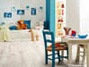 foto ambientata con sedie colorate e luce naturale di un pavimento in laminato da 8 mm Baufloor Oceano